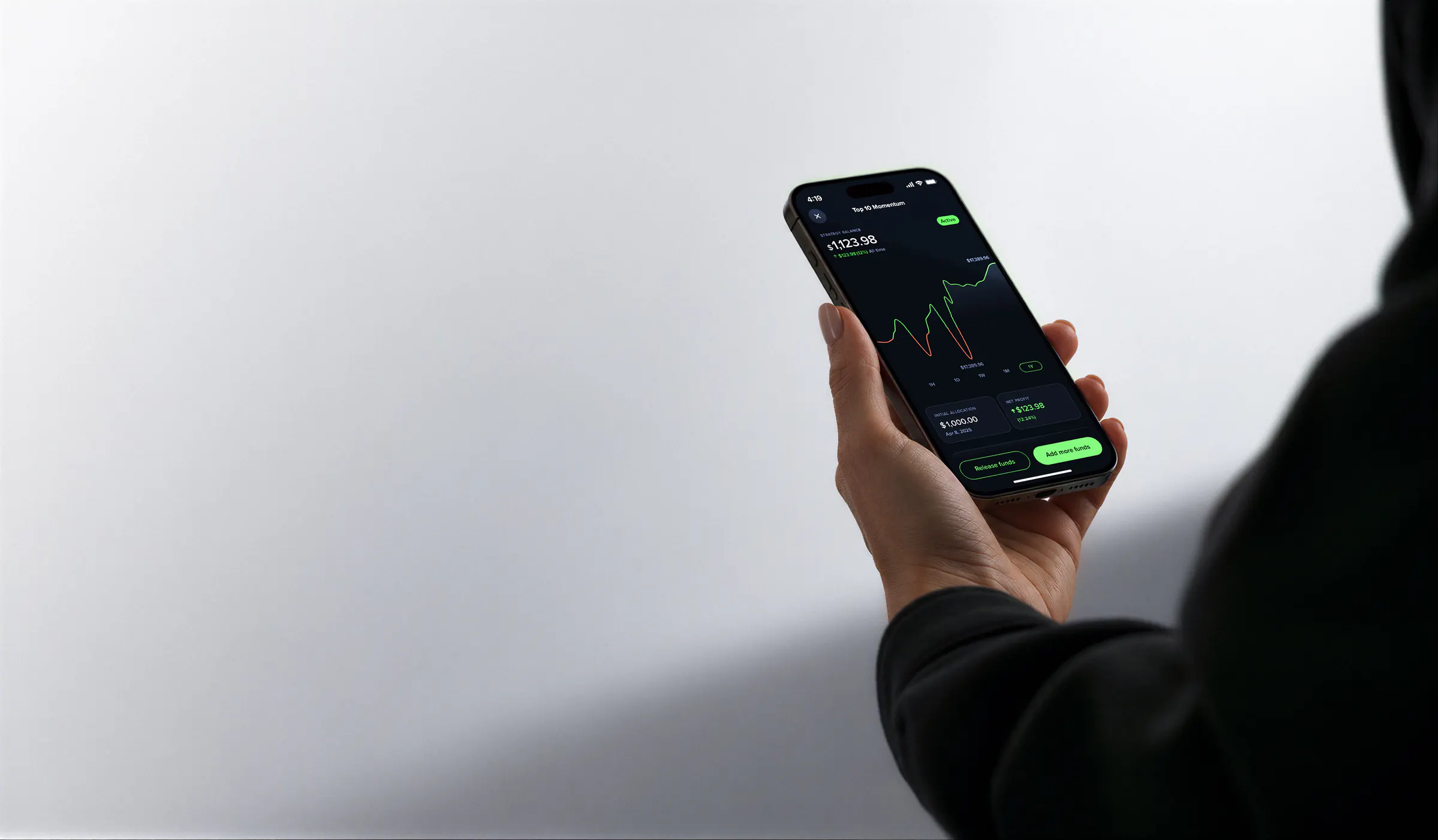A hand holding a phone showing the Uphold Autopilot Top 10 Momentum strategy, with a $1,123.98 balance and a $123.98 net profit.